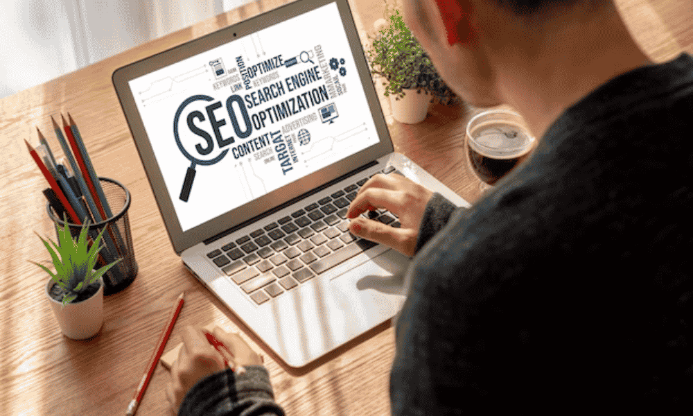 Laptop and smartphone on a desk surrounded by various digital marketing terms representing Search engine optimization Houston