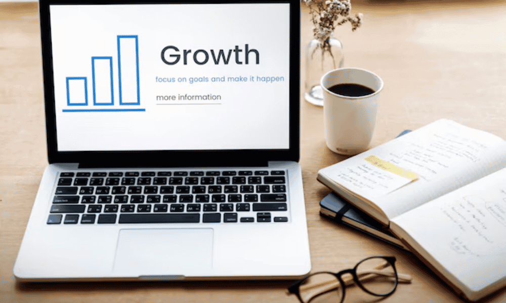 A laptop showing the word "Growth" on the screen