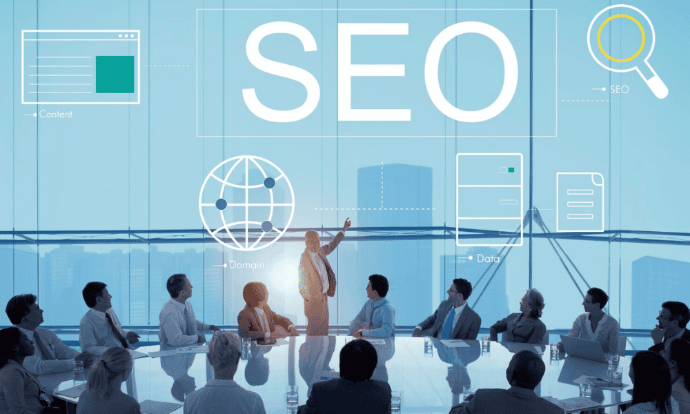 A group of business professionals in a modern boardroom listen to a presenter pointing to a digital graphic overlay about Top 100 SEO Companies in USA to Skyrocket Your Growth